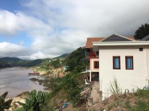 a house on a hill next to a river at Villa Mekong Guesthouse in Pakbeng