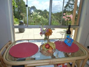 Kallista的住宿－Murrindindi，一张桌子,上面放着一碗水果和一瓶葡萄酒