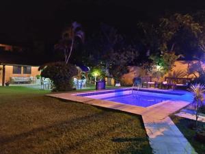 a swimming pool in a yard at night at Pousada Bella Vida Geriba in Búzios