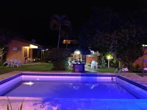 una piscina iluminada por la noche en Pousada Bella Vida Geriba, en Búzios