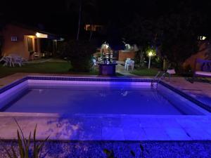 uma piscina à noite com luzes roxas em Pousada Bella Vida Geriba em Búzios