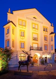 a large building with a clock on the front of it at Hotel Hirsch in Füssen
