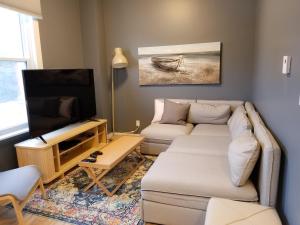 a living room with a couch and a flat screen tv at Charlotte Suites- Downtown in Ottawa
