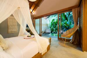 a bedroom with a bed with a hammock and a window at Kalapa Boutique Resort & Yoga in Canggu +81 photos