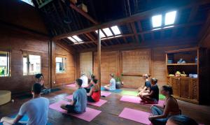a group of people sitting in a room doing yoga at Kalapa Boutique Resort & Yoga in Canggu