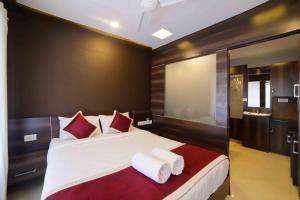 um quarto com uma cama grande e almofadas vermelhas e brancas em Ambalath Maple Leaves Home em Guruvāyūr