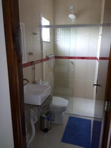 a bathroom with a sink and a toilet and a shower at Hotel Ametista in Ametista do Sul