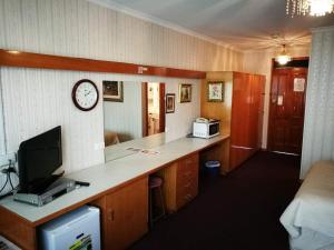 a room with a desk with a clock on the wall at Motel Mayfair on Cavell in Hobart