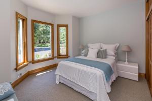 a white bedroom with a large bed and windows at BOND ESTATE LUXURY ACCOMMODATION in Christchurch +34 photos