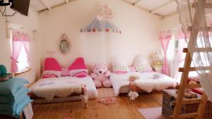 two beds in a room with pink and white at whitiedoggie Villa in Eluan