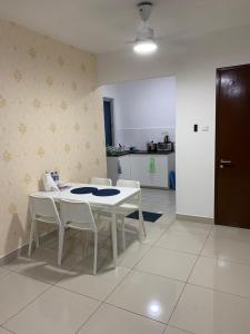 a white table and chairs in a room with a kitchen at Putra 1 Pool Homestay Bandar Seri Putra in Kampong Sungai Buah