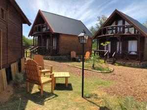 a wooden house with a bench in front of it at Cabañas Rosmar in Colón