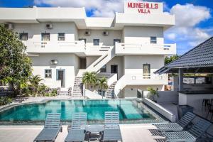 a view of a building with a swimming pool and chairs at Mui Ne Hills Villa Hotel in Mui Ne