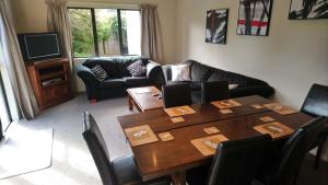 een woonkamer met een tafel met stoelen en een bank bij Foot of Turoa Chalet in Ohakune