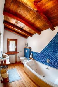 サーレ・マラジーノにあるAgriturismo Da Gesiの青いタイルの壁のバスルーム(白いバスタブ付)