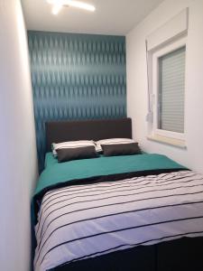 1 dormitorio con 1 cama con cabecero azul en Anja, en Bijeljina