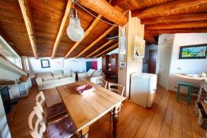 comedor y sala de estar con techo de madera en Agriturismo Da Gesi, en Sale Marasino