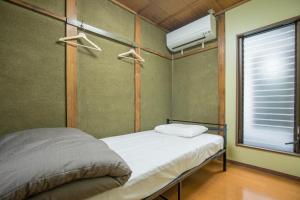 a small bedroom with a bed and a window at woodon in Osaka