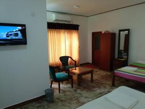 a room with a bed and a table and a chair at Ocean Gate Negombo in Negombo