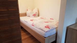 a small bedroom with a bed with pink flamingos on it at Zimmervermietung Kolkwitz - Pension Geisler in Kolkwitz