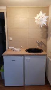 a kitchen counter with a sink and a lamp at Zimmervermietung Kolkwitz - Pension Geisler in Kolkwitz +20 photos