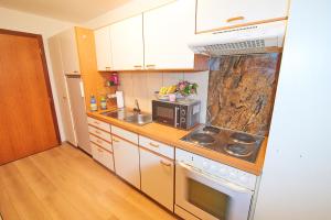 a kitchen with white cabinets and a stove top oven at Golden River in Unterseen