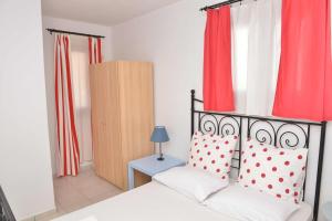a bedroom with a bed with red curtains at Paradisia Villas in Naxos Chora
