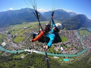 two people are hanging from a parachute at Golden River in Unterseen
