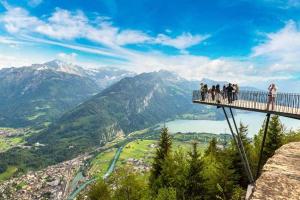 a group of people standing on a bridge overlooking a valley at Golden River in Unterseen
