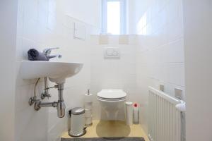 biała łazienka z umywalką i toaletą w obiekcie Central Living Apartment 1090 Vienna w Wiedniu +5 zdjęć