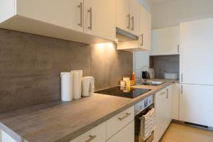 kuchnia z białymi szafkami i białą lodówką w obiekcie Central Living Apartment 1090 Vienna w Wiedniu