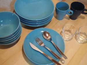 a table with blue plates and silverware on it at woodon in Osaka