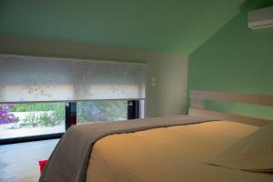 Alissachni Luxury Apartments في ديرفينيون: غرفة نوم بسرير ونافذة