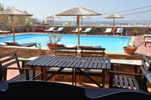 a swimming pool with a table and chairs at Paradisia Villas in Naxos Chora
