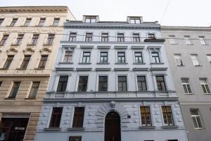 biały budynek z drzwiami przed dwoma budynkami w obiekcie Central Living Apartment 1090 Vienna w Wiedniu