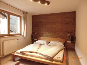 Cama en habitación con pared de madera en Haus Wachter Anke, en Gaschurn