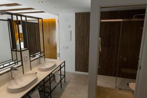 a bathroom with two sinks and two mirrors at Vinatea Suites in Morella