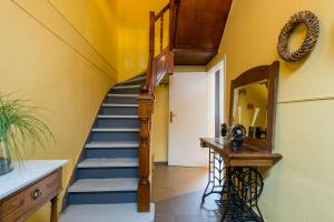 a hallway with a spiral staircase and a mirror at Huyze Aïda in Bruges +7 photos