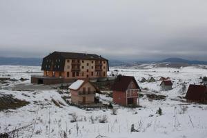 a group of buildings in a snow covered field at Apartman Kupres Holiday in Kupres