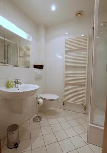 uma casa de banho branca com um lavatório e um chuveiro em Ferienhaus Vera em Moritzburg