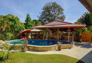 a swimming pool in a yard with a pavilion at Tina's Living Paradise - Guesthouses with private pool in Ban Phe