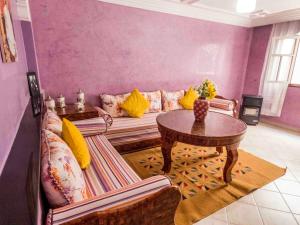 ein Wohnzimmer mit einem Sofa und einem Tisch in der Unterkunft Chez Ali Apartments in Essaouira