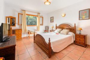 a bedroom with a bed and a tv in a room at Villa Can Turrent in Sant Carles de Peralta