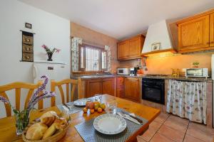 a kitchen with a table with a bowl of fruit on it at Villa Can Turrent in Sant Carles de Peralta +32 photos