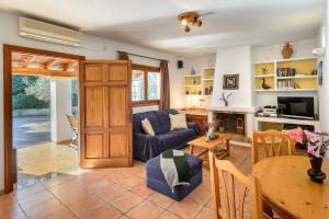 a living room with a blue couch and a table at Villa Can Turrent in Sant Carles de Peralta