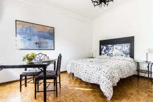 1 dormitorio con 1 cama y 1 mesa con sillas en B&B Viale Dei Colli Portuensi 589, en Roma