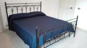 1 cama con edredón azul y manta azul en Kali Nitta Salento en Sant'Isidoro