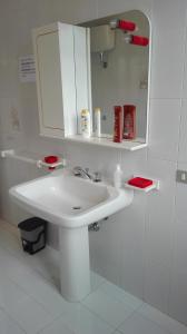 Baño blanco con lavabo y espejo en Kali Nitta Salento en Sant'Isidoro