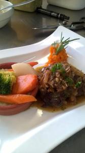 un plato de comida con carne y verduras en una mesa en Hôtel restaurant HENRY, en Puy-lʼÉvêque