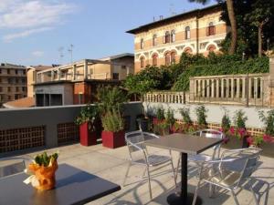 un tavolo e sedie su un balcone con un edificio di Hotel Milano ad Ancona